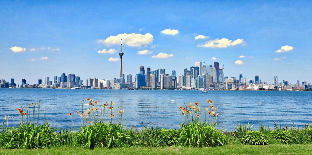 pexels-photo-457937-457937 Scenic view of Toronto skyline with CN Tower against a clear blue sky, seen from across the waterfront.